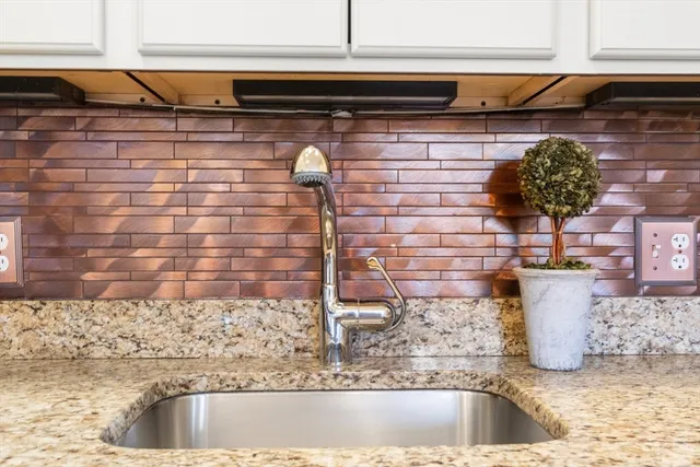 a bedroom with a large bed chandelier and a window