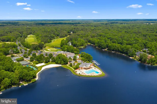 an aerial view of lake residential house with swimming pool and outdoor seating