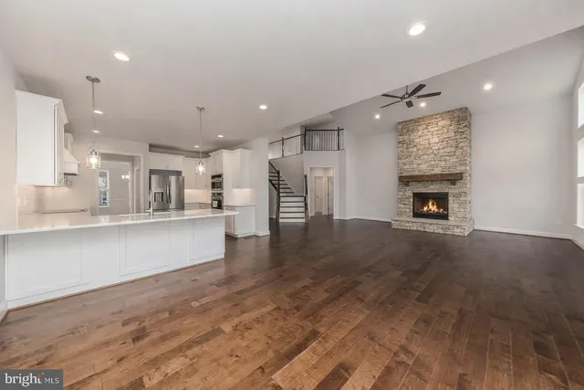 a large kitchen with kitchen island a stove a sink a center island and wooden floor