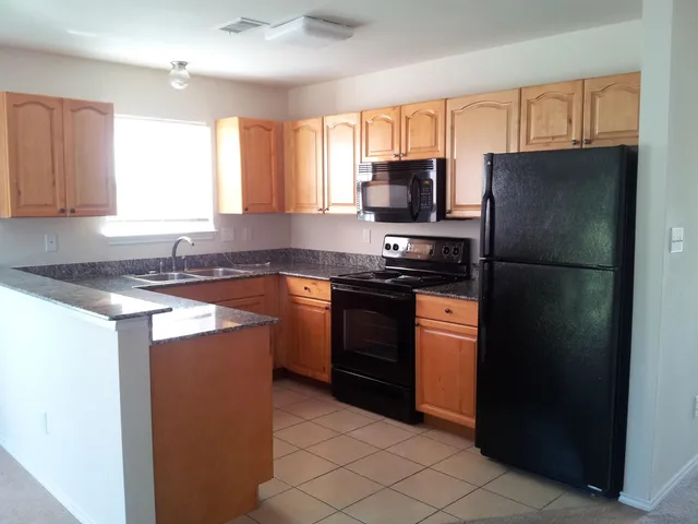 a kitchen with a refrigerator stove top oven and sink