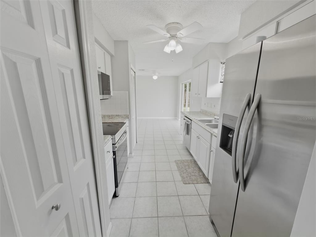 2202 Godfrey Avenue Spring Hill, FL 34609 - Photo 17 of 36 a kitchen with white cabinets and white stainless steel appliances