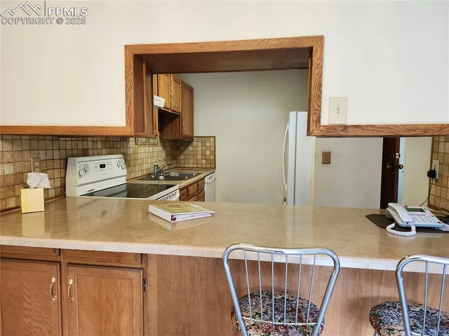 a kitchen with a sink a stove and a wooden floor