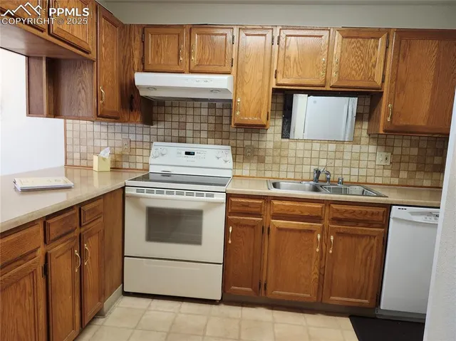 a kitchen with granite countertop a sink stove and cabinets