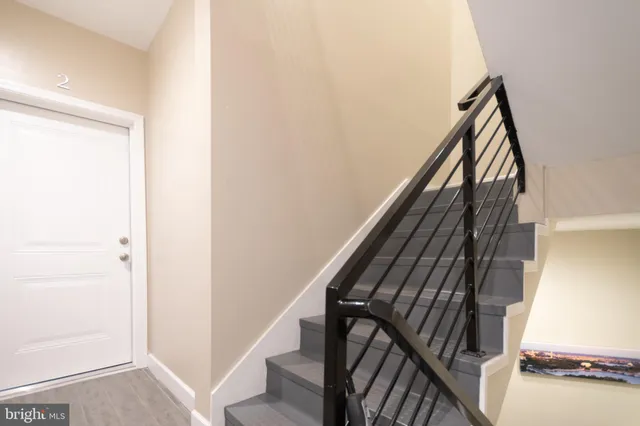 a view of staircase with wooden floor and white walls