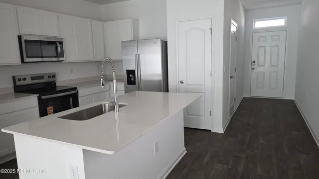 a kitchen with stainless steel appliances a microwave a sink and cabinets