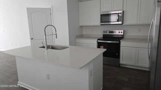 a kitchen with a refrigerator and a stove top oven
