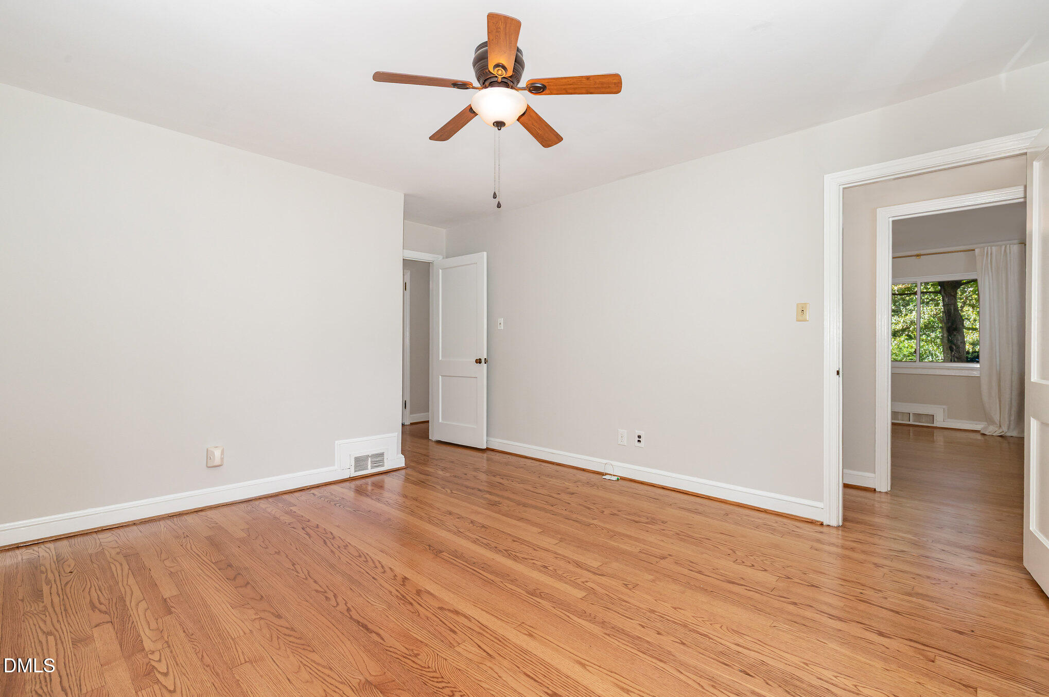 1316 Dixie Trail Raleigh, NC 27607 - Photo 24 of 36 an empty room with wooden floor ceiling fan and window