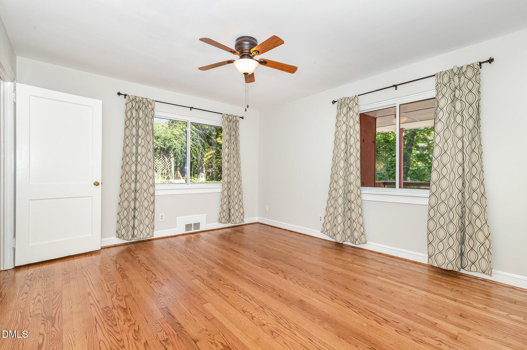 1316 Dixie Trail Raleigh, NC 27607 - Photo 25 of 36 a view of an empty room with wooden floor and a window