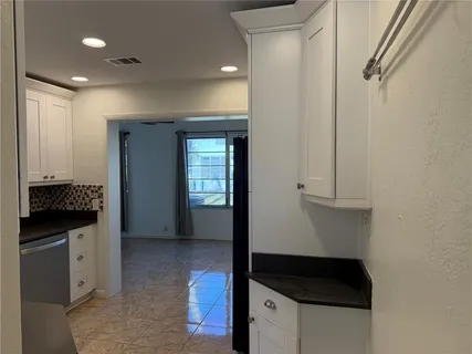 a view of hallway with cabinets and wooden floor