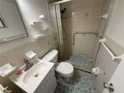 a white toilet sitting next to a bathroom sink and shower
