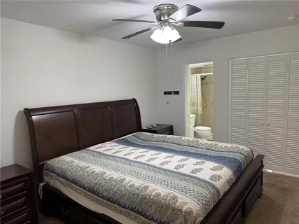 a bedroom with a bed and a ceiling fan