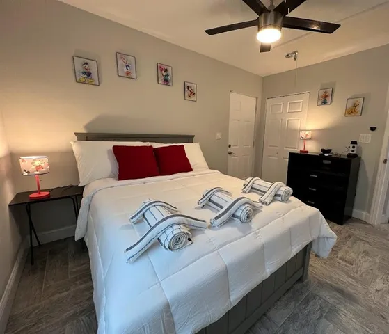 a bedroom with a bed and lamp on dresser