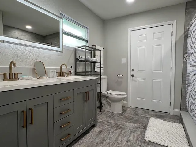 a spacious bathroom with a toilet a sink and mirror