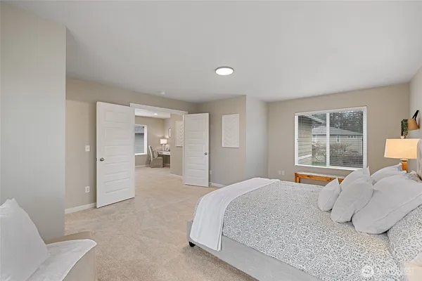 a spacious bedroom with a bed and a large window