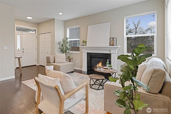 a kitchen with stainless steel appliances granite countertop a sink a stove a refrigerator a dining table and chairs with wooden floor