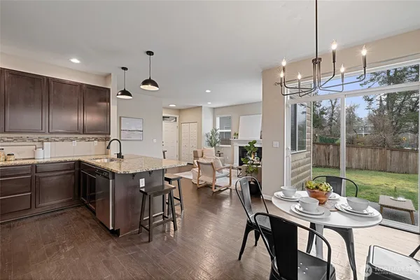 a kitchen with kitchen island granite countertop stainless steel appliances and wooden cabinets