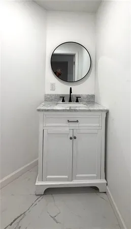 a room with a sink and mirror