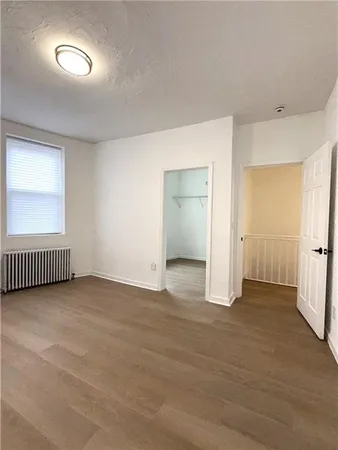 an empty room with a window and a bathroom