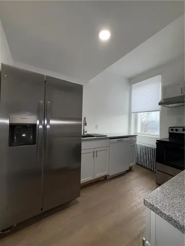 a kitchen with stainless steel appliances granite countertop a refrigerator a sink and wooden cabinets