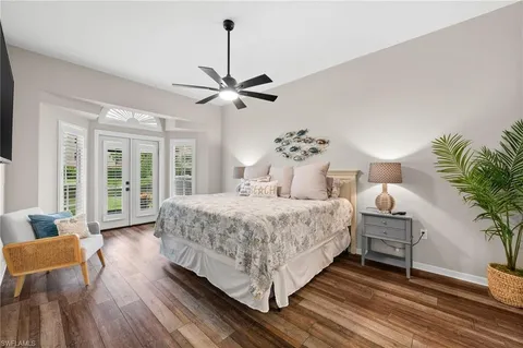 a bedroom with a large bed chandelier and a window