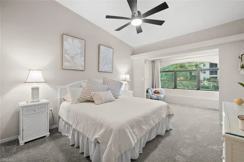 a bedroom with a large bed and a chandelier fan