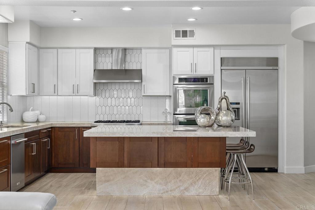 13251 Devon Drive Jamul, CA 91935 - Photo 42 of 73 a kitchen with kitchen island granite countertop a stove top oven a sink and cabinets