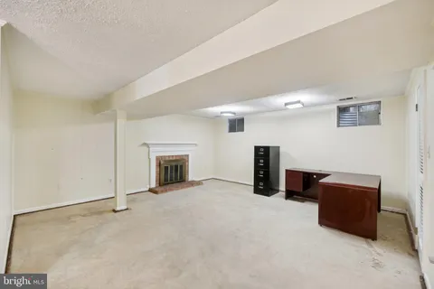a view of an empty room with furniture and a fireplace