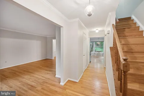 a view of a hallway with wooden floor and staircase