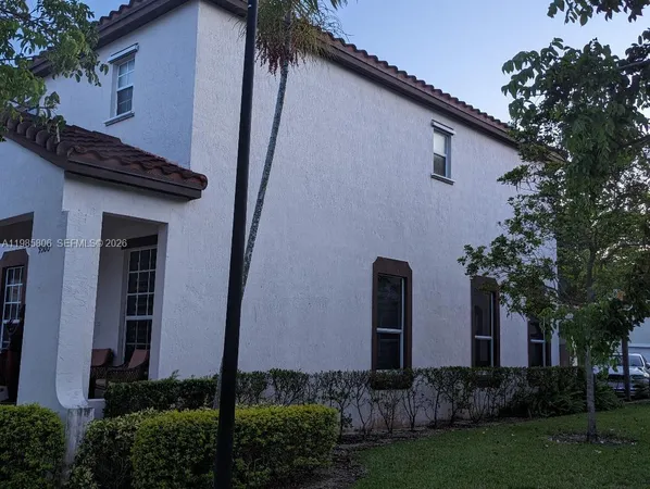 a view of a house with brick walls and a tree