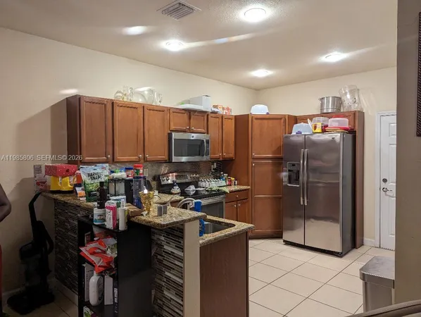 a kitchen with refrigerator and microwave