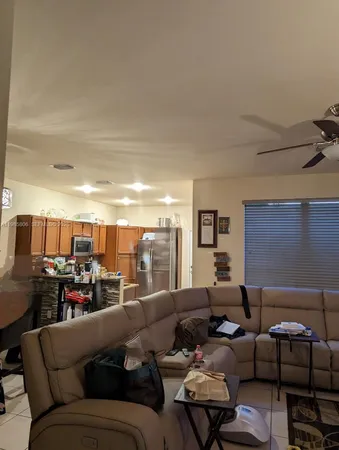 a living room with furniture and a view of kitchen