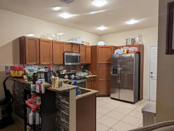 a kitchen with refrigerator and cabinets
