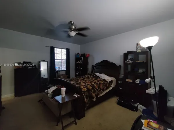 a bedroom with bed mirror and dresser