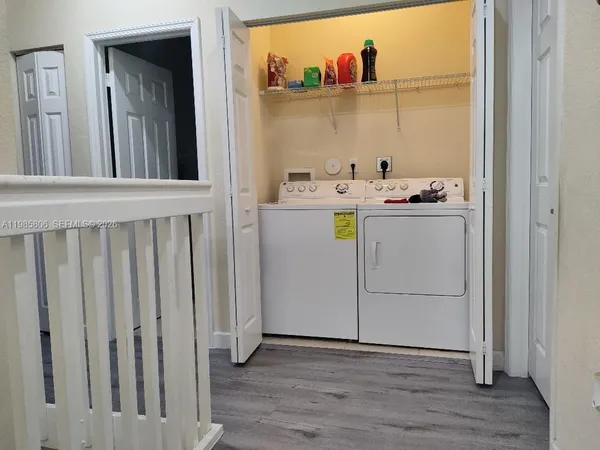 a storage room with wooden floor washer and dryer