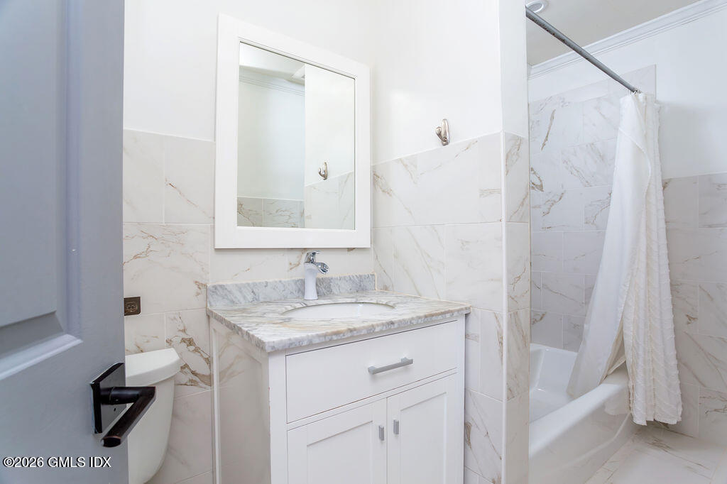 198 Valley Road Cos Cob, CT 06807 - Photo 19 of 31 a bathroom with a granite countertop sink a mirror and a shower