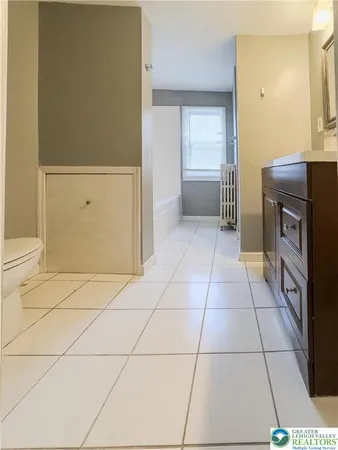a bedroom with a bed a dresser and a window
