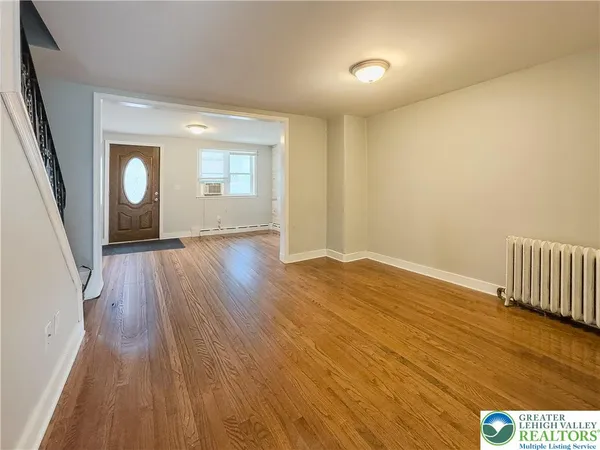 an empty room with wooden floor and mirror