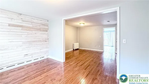 a view of empty room with wooden floor