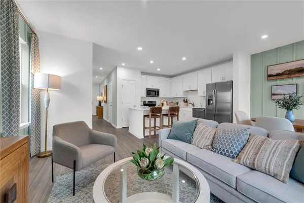 a living room with furniture and a view of kitchen