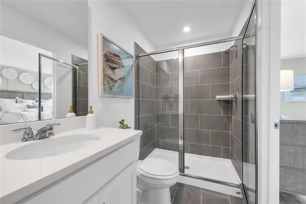 a bathroom with a granite countertop toilet a sink and mirror