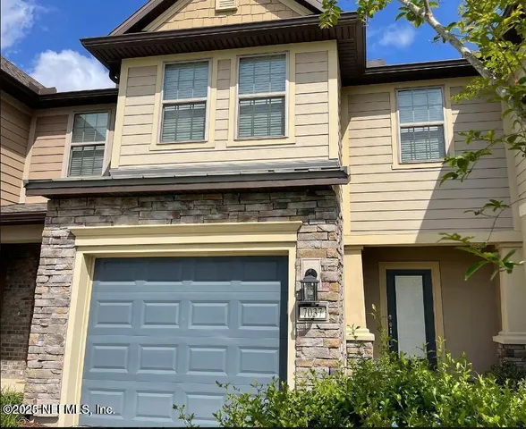 a view of an empty room with a floor to ceiling window next to a yard