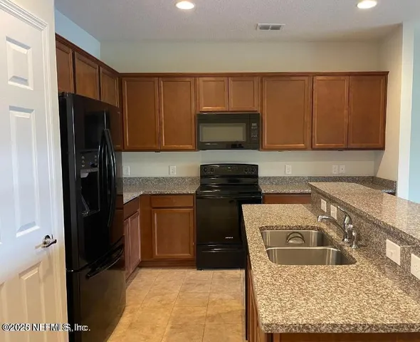 a kitchen with kitchen island a sink a stove and a refrigerator