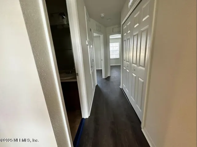 an empty room with wooden floor and window