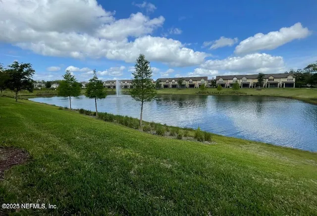 a view of a house with brick walls and a yard with plants