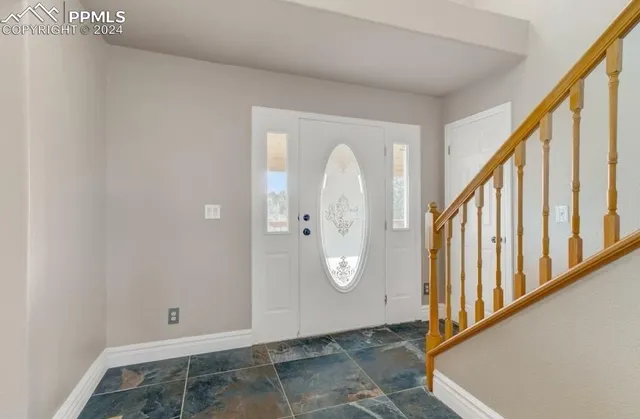 a view of an empty room with a fireplace and a window