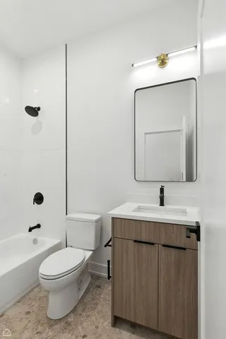 a bathroom with a toilet a sink a tub and mirror
