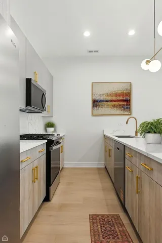 a kitchen with a sink cabinets and stainless steel appliances