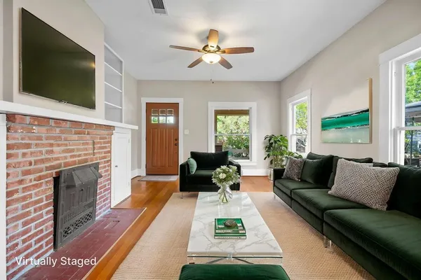 a living room with furniture a flat screen tv and a fireplace