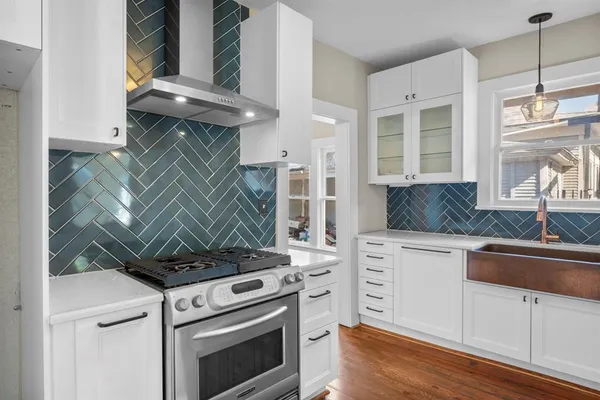 a kitchen with white cabinets and appliances
