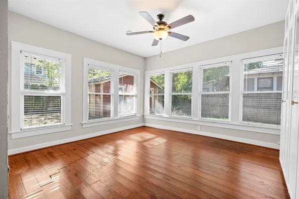 a view of an empty room with a window and wooden floor